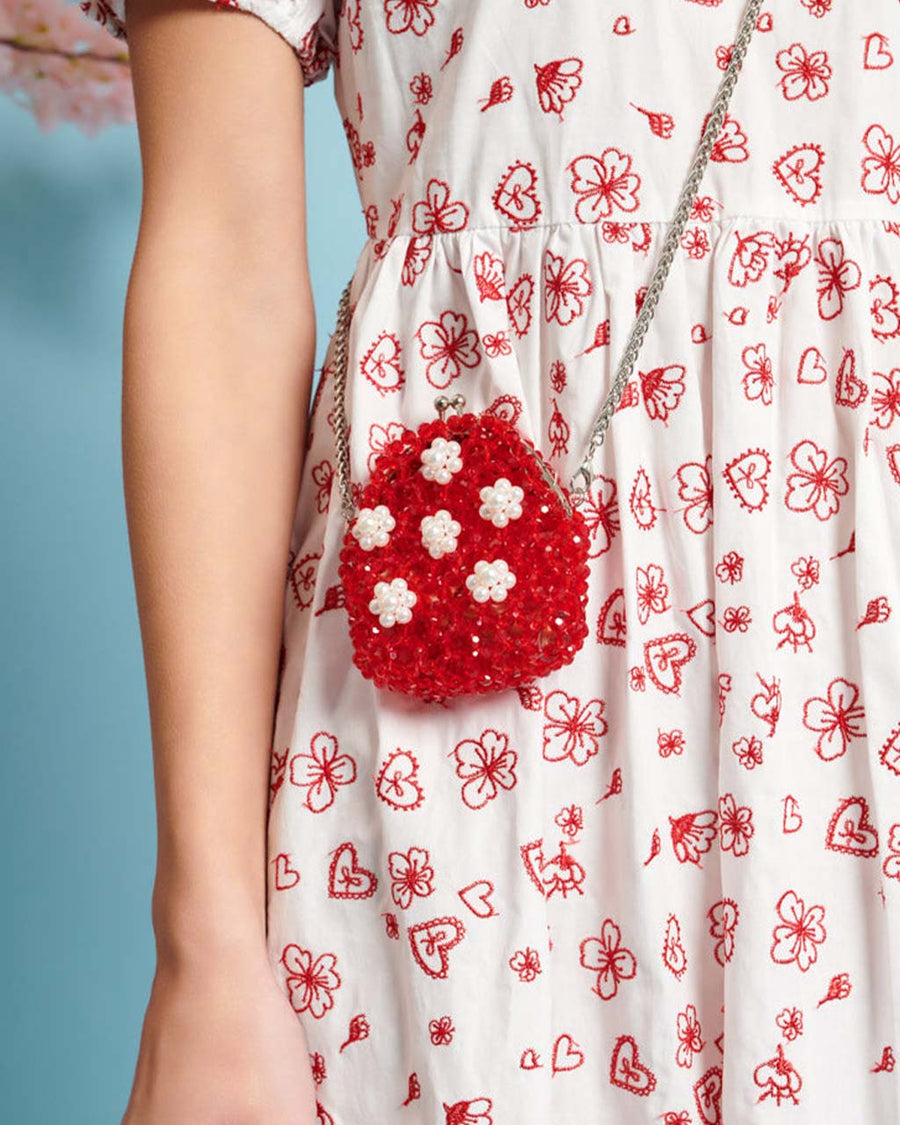 model wearing red beaded change purse with white beaded flowers