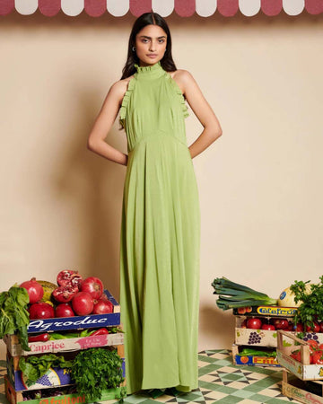 model wearing green dress with subtle shine, ruffle trim and halter neckline