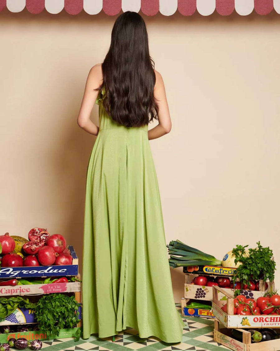 back view of model wearing green dress with subtle shine, ruffle trim and halter neckline