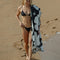 model holding cream and black large floral driftweave beach blanket