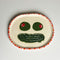 handmade tray with olive eyes and dill pickle smiley face with pink and red trim