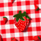 strawberry shaped dish on a red picnic tablecloth