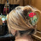 model wearing green hair claw with vintage red poppy flower