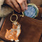 model placing blue and gold pill compact with a cross-stitch DRUGS and vine border in their purse