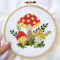 model holding completed colorful mushroom cross stitch kit