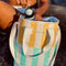 model pulling drink out of yellow/white and mint/white striped drink cooler