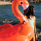 model holding pink flamingo inflatable float