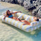 models floating on oversized pastel yellow and white stripe float for two people