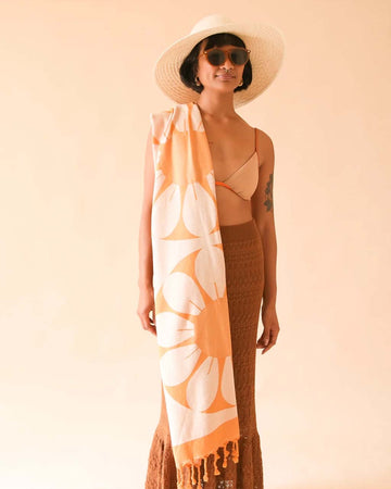 model with orange and white retro flower towel with tassels on the end