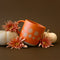 orange ceramic mug with floral border design