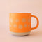 orange ceramic mug with floral border design