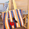 orange, dark blue and light blue plaid recycled plastic tote with ribbon detail and tomato applique on a chair