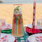 set of 2 lilac dinner candles with all over strawberry print on a table next to a colorful pitcher