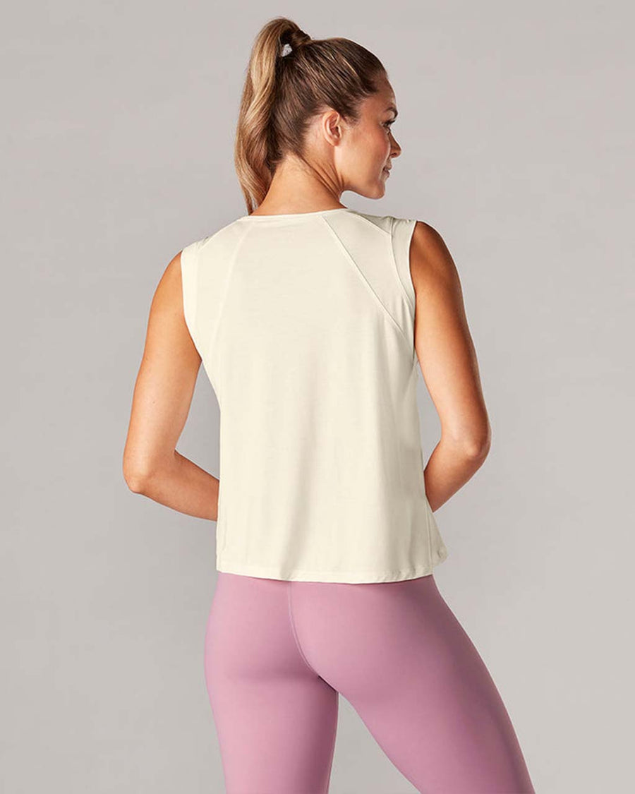back view of model wearing sand active tank with hi-lo hem and muscle tank sleeves