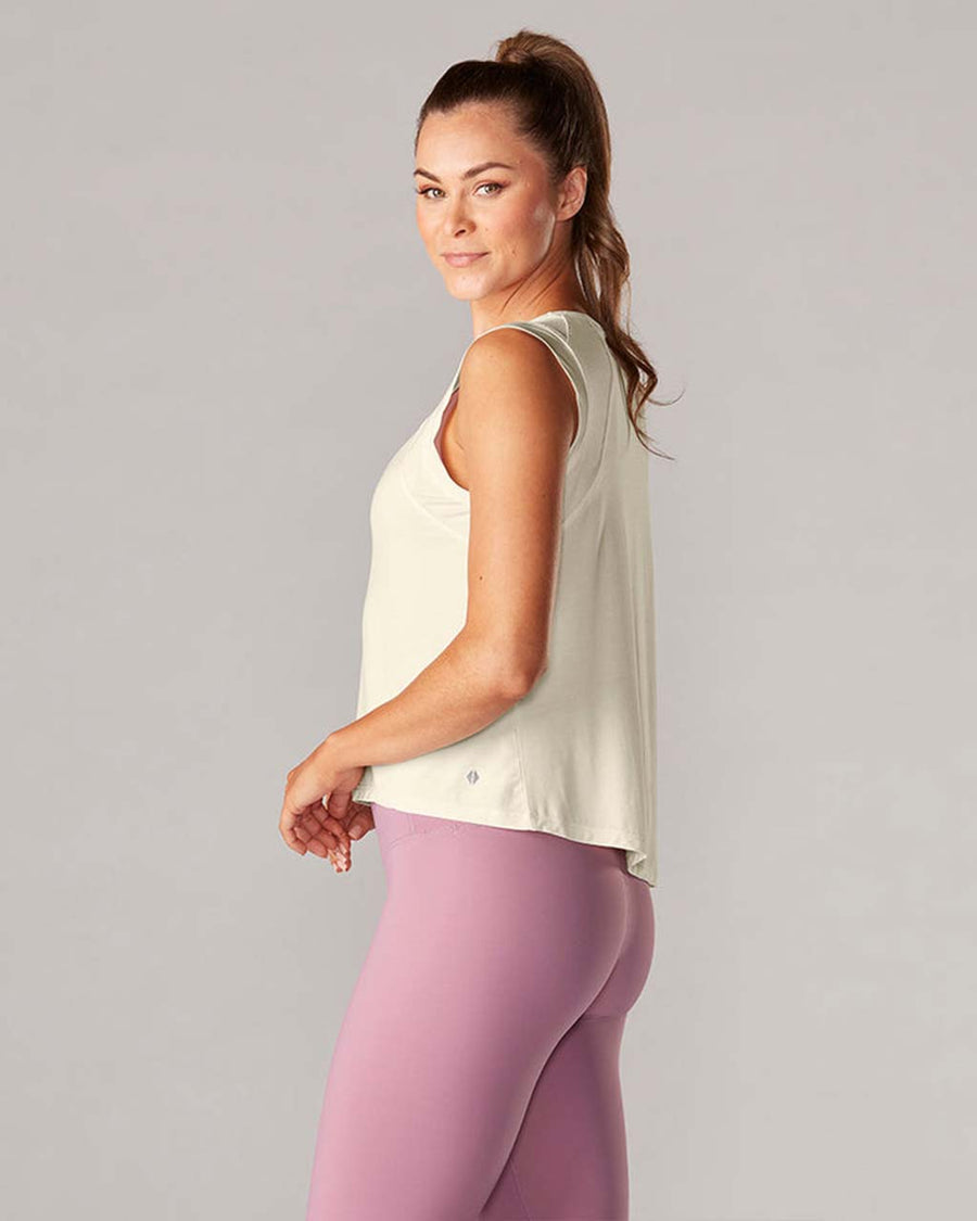side view of model wearing sand active tank with hi-lo hem and muscle tank sleeves
