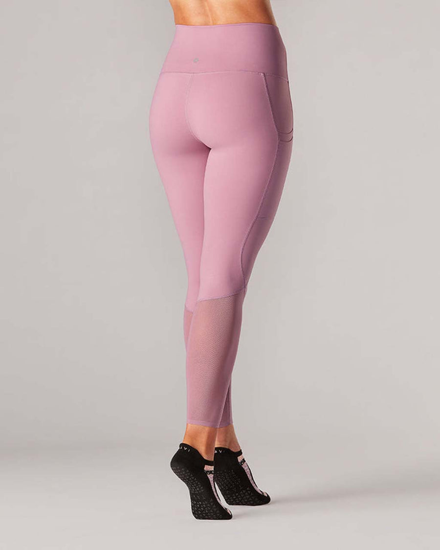back view of model wearing wisteria leggings with mesh legs and side pockets