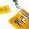 up close of golden yellow zip lanyard wallet with snoopy skateboarding