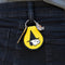 yellow and black patch keychain with snoopy in a witch hat hanging form the models belt loop