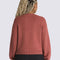 back view of model wearing pink cropped cardigan with button front and vans logo on the left chest
