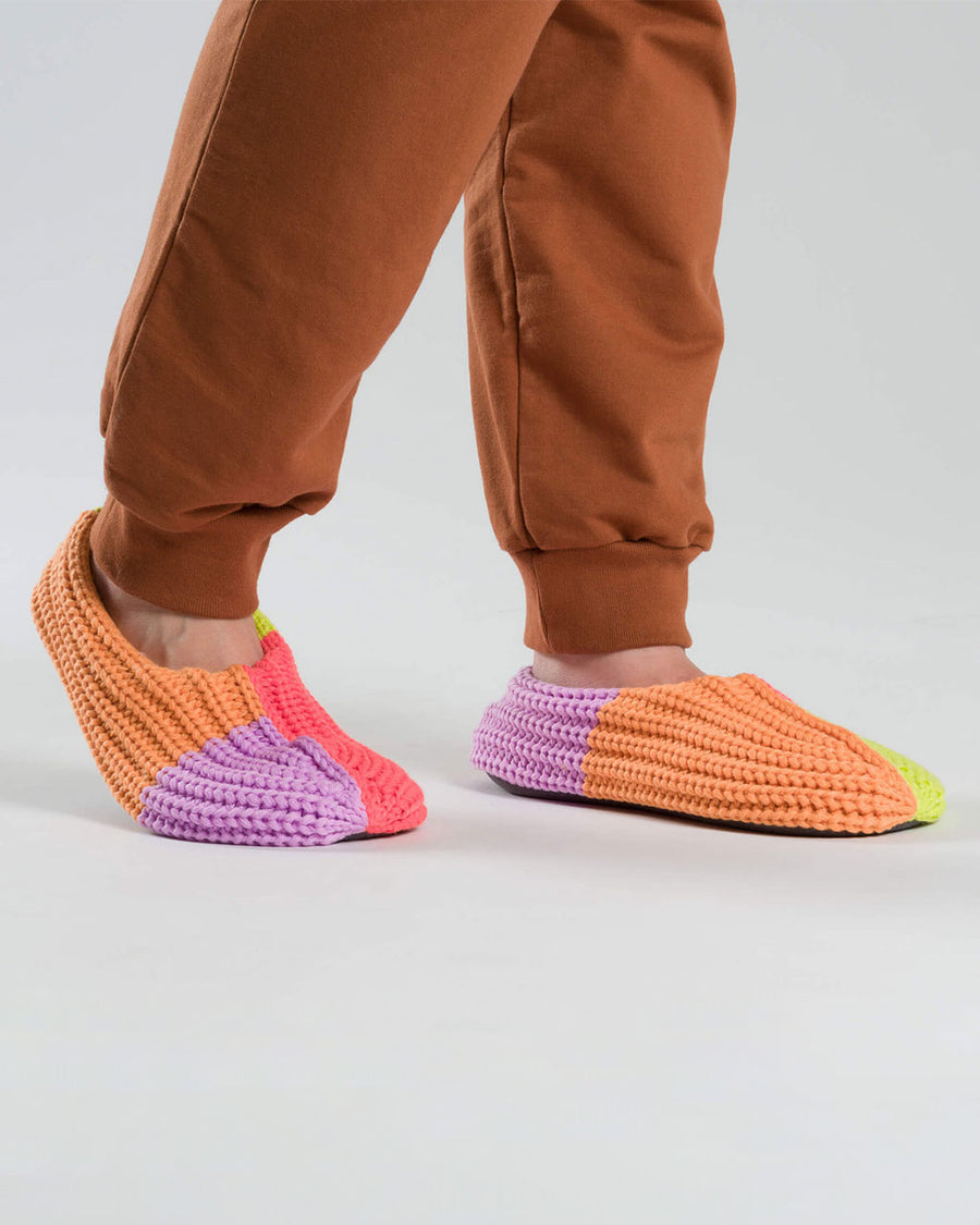 model wearing pink, orange, lime and lilac colorblock slippers
