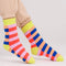 side view of blue, orange, coral, lavender striped socks with yellow trim
