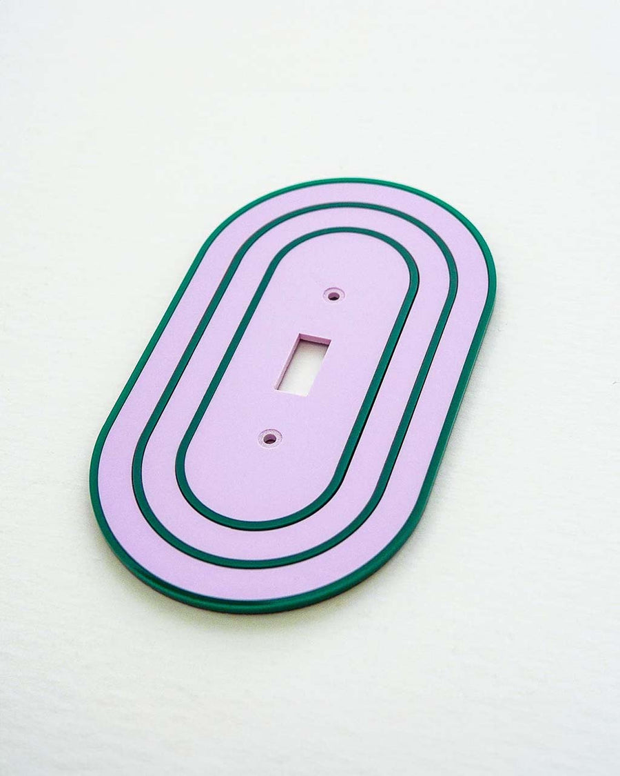 side view of lilac toggle light switch cover with dark green accent color