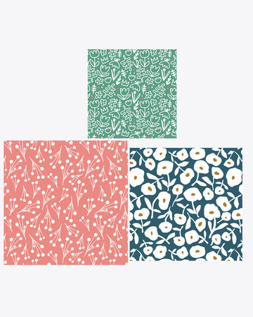 set of 3 reusable wraps: small - green ground with white abstract flowers, medium - blue ground with large white flowers, and large - coral ground with dainty white flower print
