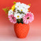 strawberry vase with floral arrangement inside