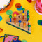 primary colored peg game with wooden base and 15 pegs on table