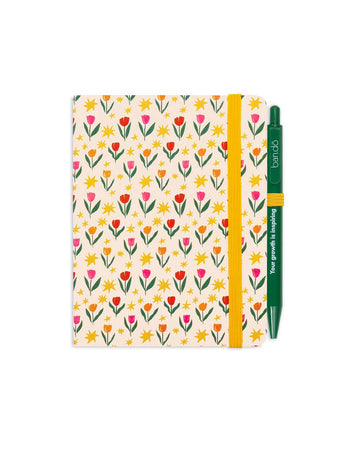 cream mini notebook with floral and star print with yellow elastic and green ban.do pen that says 'your growth is inspiring'