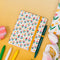 cream mini notebook with floral and star print with yellow elastic and green ban.do pen that says 'your growth is inspiring'