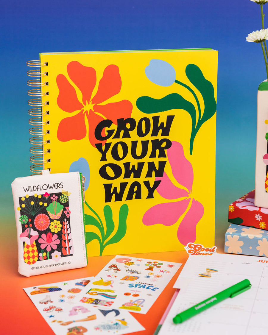 three subject notebook with yellow cover and abstract floral and black 'grow your own way' text