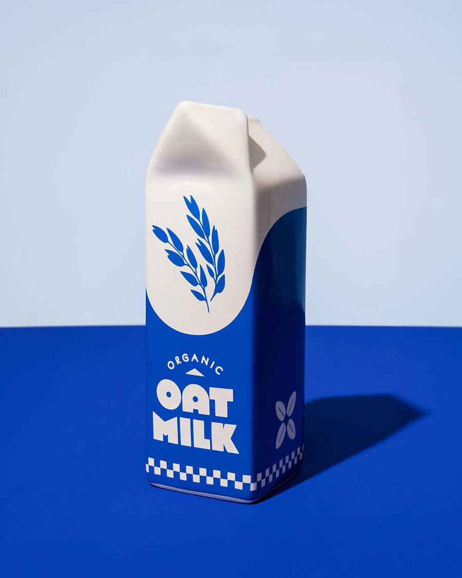 white and blue carton shaped ceramic vase with 'organic oat milk' across the front