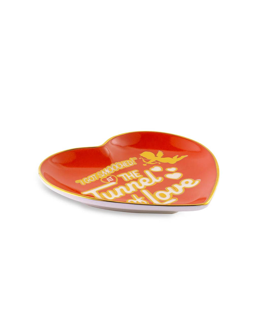 side view of red heart shaped trinket tray that says 'i got smooched at the tunnel of love' in white and metallic gold
