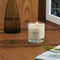 The Le Refuge Dernest candle by Maison Louis Marie is white and comes in a clear glass tumbler on a table