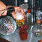 Pouring sparkling drink into a tipsy turvy bar glass