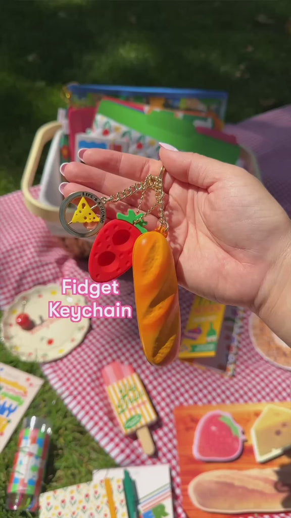 model using strawberry, cheese, and baguette fidget keychain