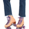 These peach-colored roller-skates feature purple laces and sparkly purple wheels.