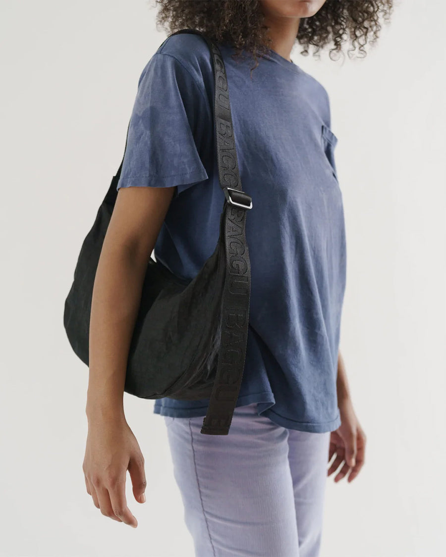 model wearing black medium crescent bag