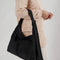 model holding black nylon shoulder bag