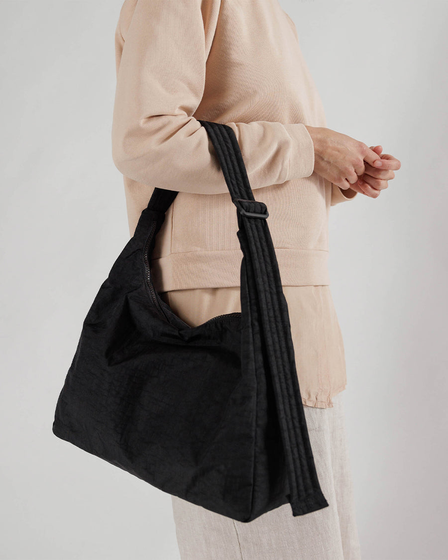 model holding black nylon shoulder bag