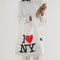 model holding white standard baggu with traditional 'I love NY' graphic