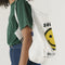 model carrying white standard baggu with yellow smiley and 'baggu- have a nice day!' text