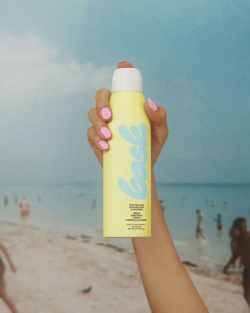 model holding non-aerosol spf 30 sunscreen spray