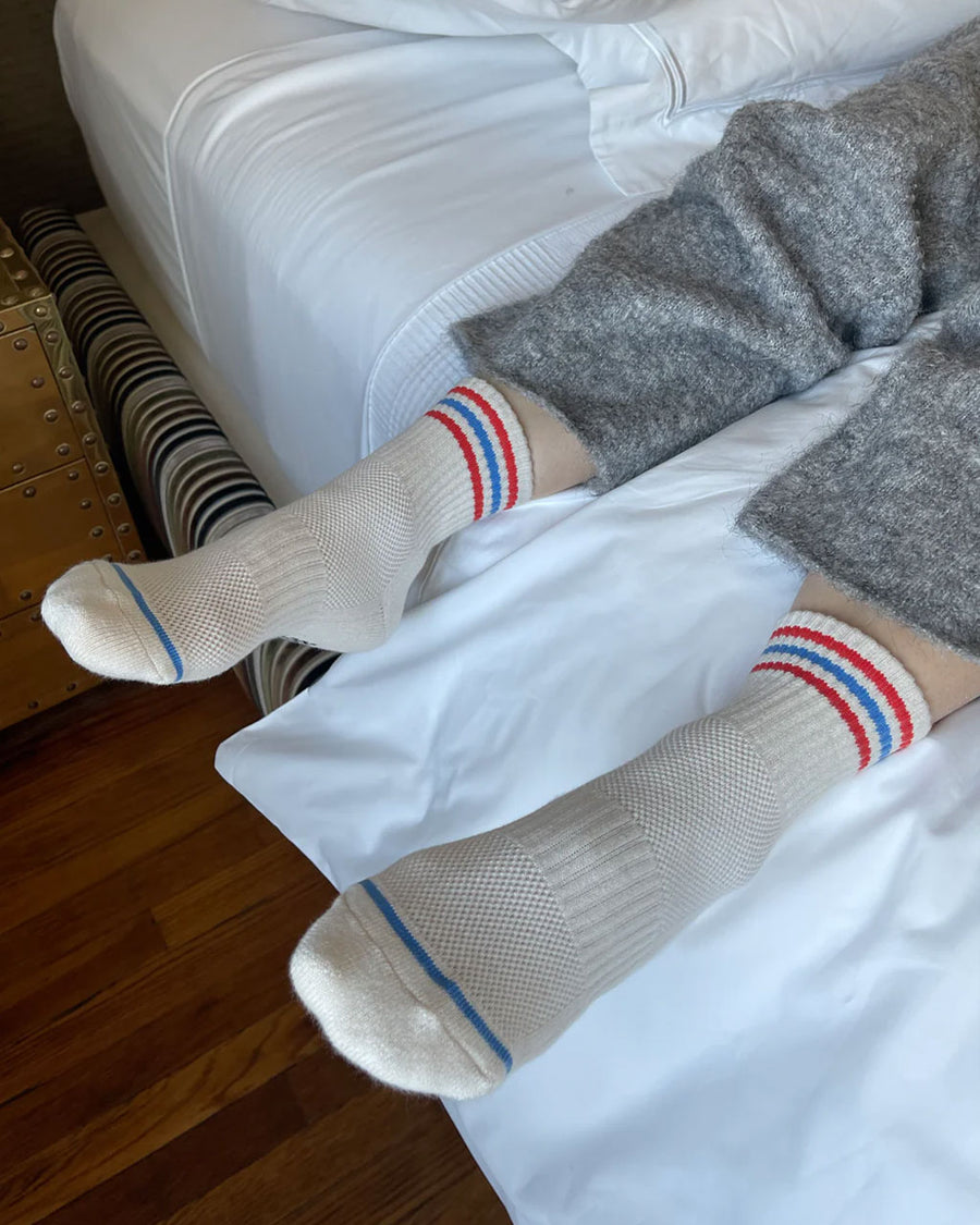model wearing pair of white socks with red and blue stripe accents