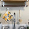 lemon print swedish dish cloth hanging over a kitchen sink