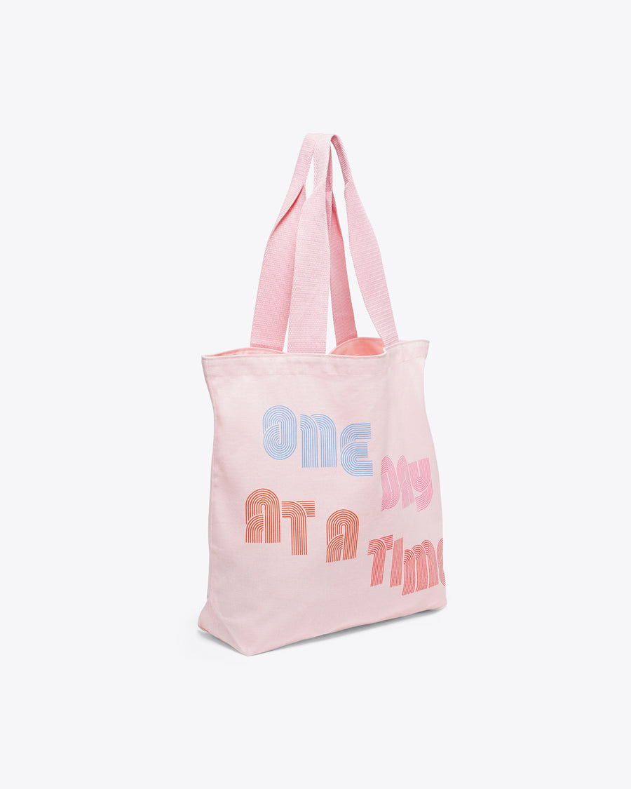 side view of pink canvas tote with "ONE DAY AT A TIME" text graphic