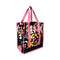 sideview of reusable market bag with black ground, pink trim/straps, and all over multicolor abstract floral print