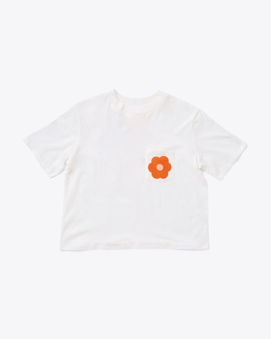 white boxy white tee with a flower on the pocket
