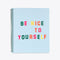 large notebook featuring a light blue cover with the words be nice to yourself, in various colors